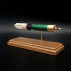 Rear-right perspective of a handcrafted Remington 12 Gauge AccuTip slug display featuring the expanded primer cup, anvil, battery cup, green hull, exposed simulated powder, sabot, and copper projectile with green polymer tip mounted on a walnut wood base.