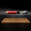 Front profile of an exploded Winchester AA 12 Gauge 7.5 Shot shotgun shell display featuring the red hull, exposed simulated powder, wad, #7.5 lead shot payload, and expanded primer assembly with primer cup, anvil, and battery cup mounted on a handcrafted walnut wood presentation base.