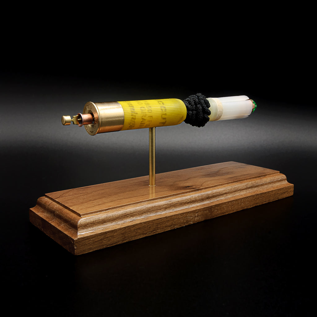 Side view of a Remington AccuTip 20 gauge slug display featuring separated shotshell components on walnut base