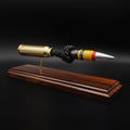 Angled front view of a 20mm Vulcan SAPHEI round on a Bolivian rosewood base, showing the painted projectile tip and exposed internal section