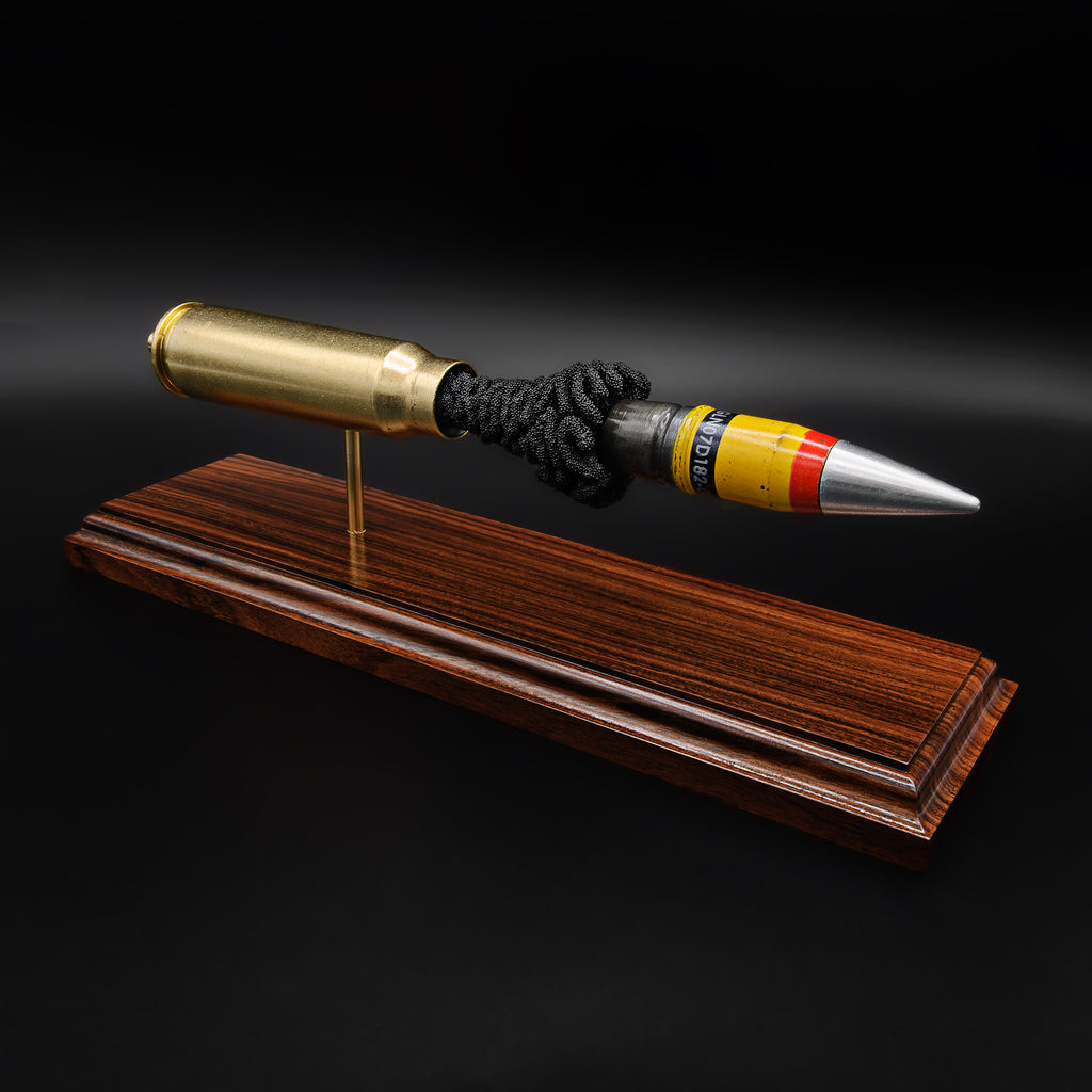 Close angled view of a 20mm Vulcan cartridge model focusing on the connection between the casing and projectile with exposed internal material