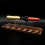Side view of a 20mm Vulcan MK244 APDS anatomy cartridge display with exposed penetrator and simulated powder on walnut base