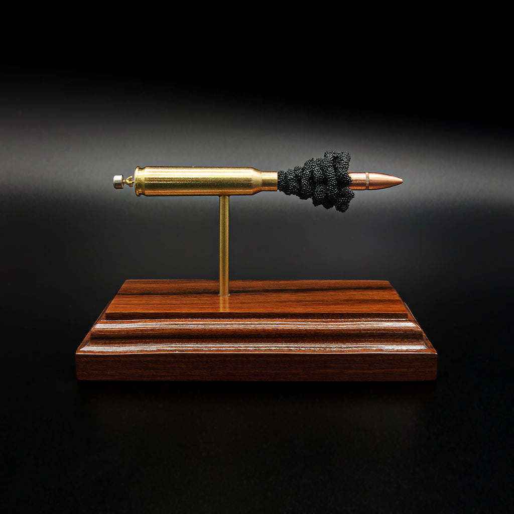 Side profile of a handcrafted .223 Remington FMJ anatomy cartridge display showcasing the exposed internal components including the bullet, brass case, simulated powder, primer assembly, and Bolivian rosewood base.