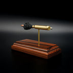 Detailed perspective of a .223 Remington FMJ exploded cartridge display mounted on a handcrafted Bolivian rosewood base, revealing the bullet, brass case, simulated powder, and expanded primer assembly including the primer cup, anvil, and battery cup.