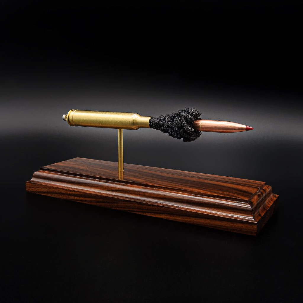Angled view of a .300 Weatherby Magnum Hornady Precision Hunter 200gr ELD-X cartridge anatomy display highlighting the projectile, simulated powder, cartridge case, primer cup, and anvil on a Bolivian rosewood base.
