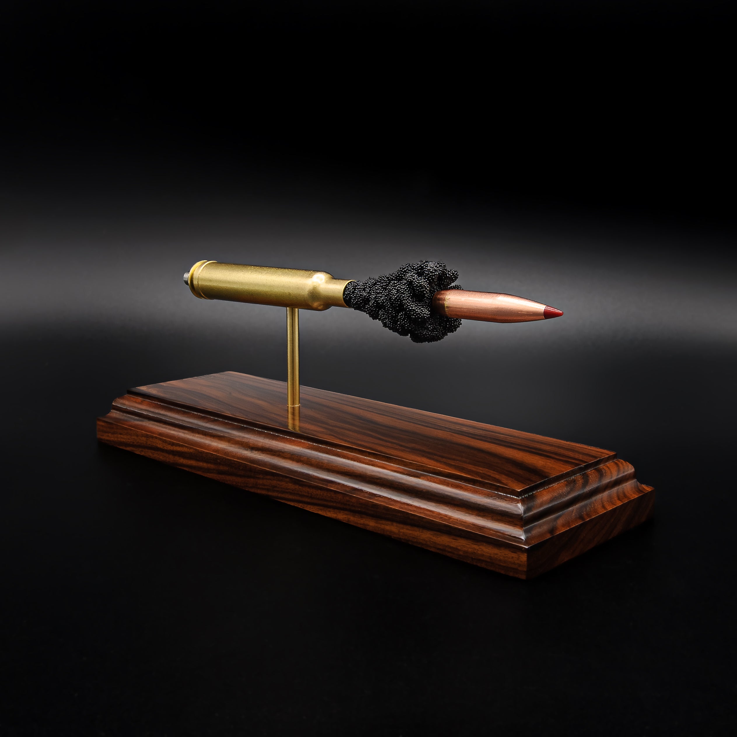 Side view of a .300 Weatherby Magnum Hornady Precision Hunter 200gr ELD-X cartridge anatomy display with the primer cup, anvil, cartridge case, simulated powder, and projectile visible on a Bolivian rosewood base.