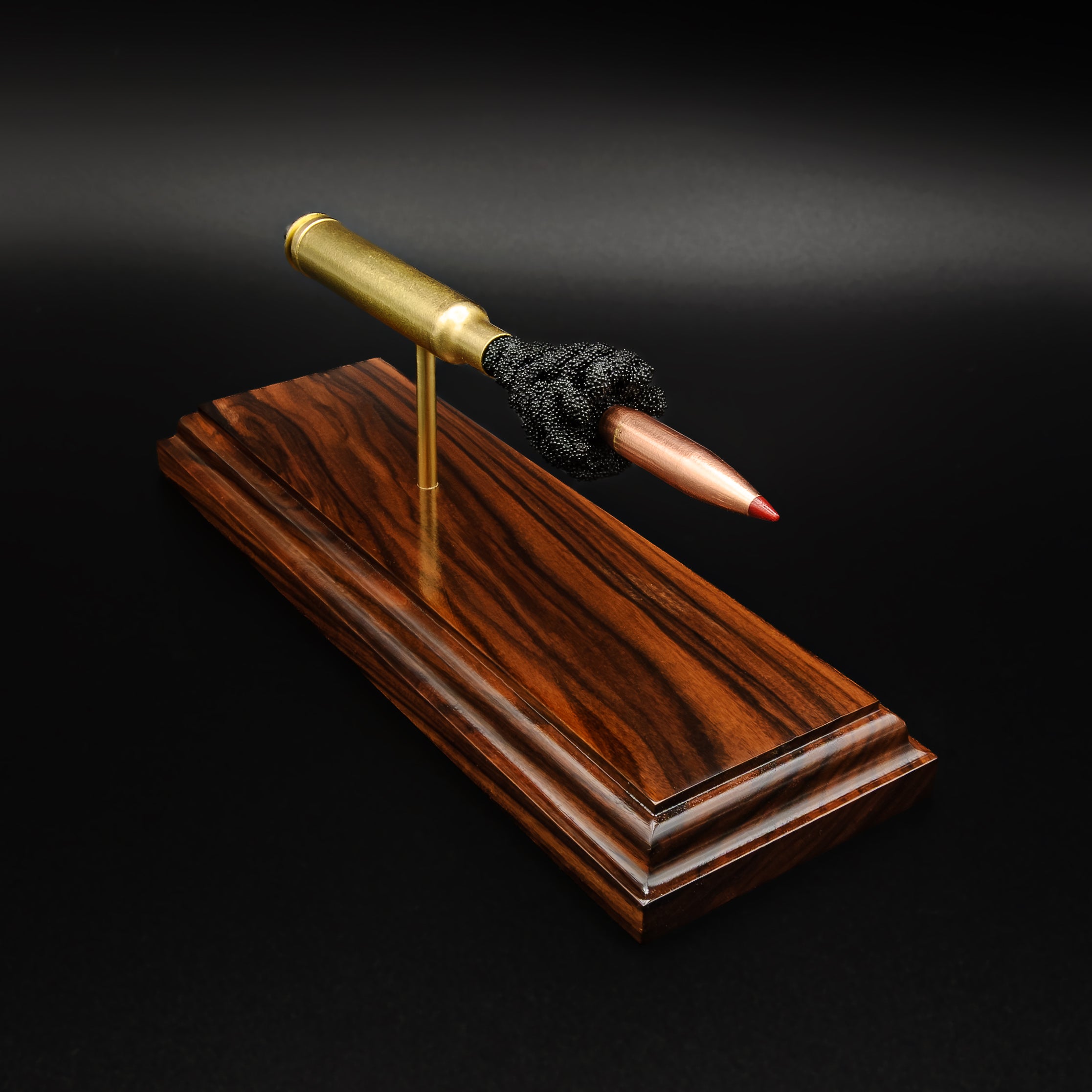 Front angled view of a .300 Weatherby Magnum Hornady Precision Hunter 200gr ELD-X cartridge anatomy display with the primer cup, anvil, cartridge case, simulated powder, and projectile mounted on a Bolivian rosewood base.