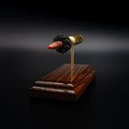 Front angled view of a .300 WSM cartridge anatomy display with the primer cup, anvil, cartridge case, simulated powder, and projectile mounted on a Bolivian rosewood base.