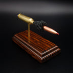 Raised front angled view of a .300 WSM cartridge anatomy display highlighting the projectile, simulated powder, cartridge case, primer cup, and anvil on a Bolivian rosewood base.