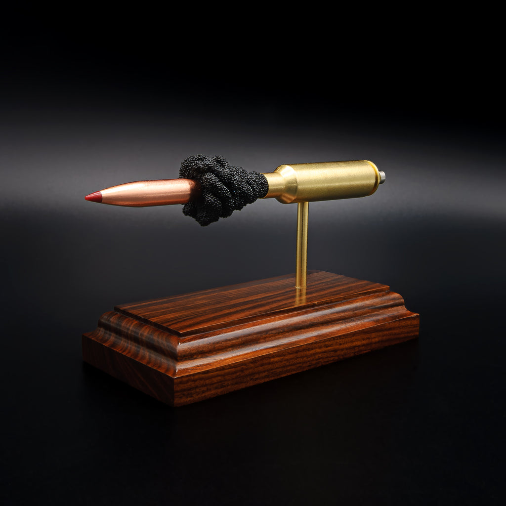 Opposite side view of a .300 WSM cartridge anatomy display showing the primer cup, anvil, cartridge case, simulated powder, and projectile on a Bolivian rosewood base.