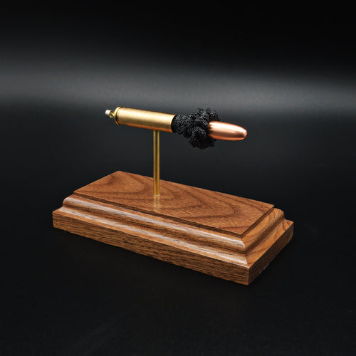 Angled view of 30 Carbine full metal jacket cartridge display on walnut base