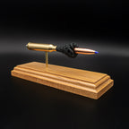 .338 Lapua Magnum Barnes TTSX exploded cartridge anatomy model displayed on a cherry wood base
