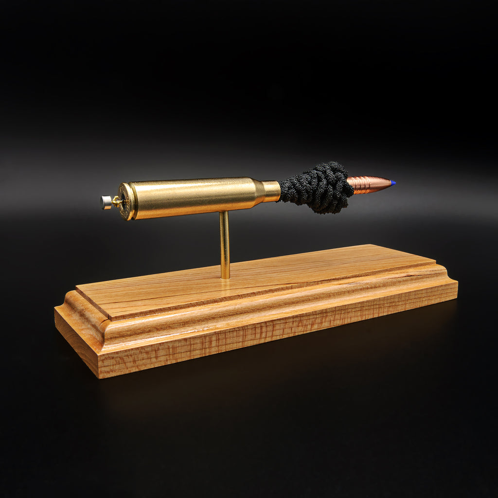 Rear angled view of .338 Lapua Magnum display showing case head and primer with exploded components on cherry base