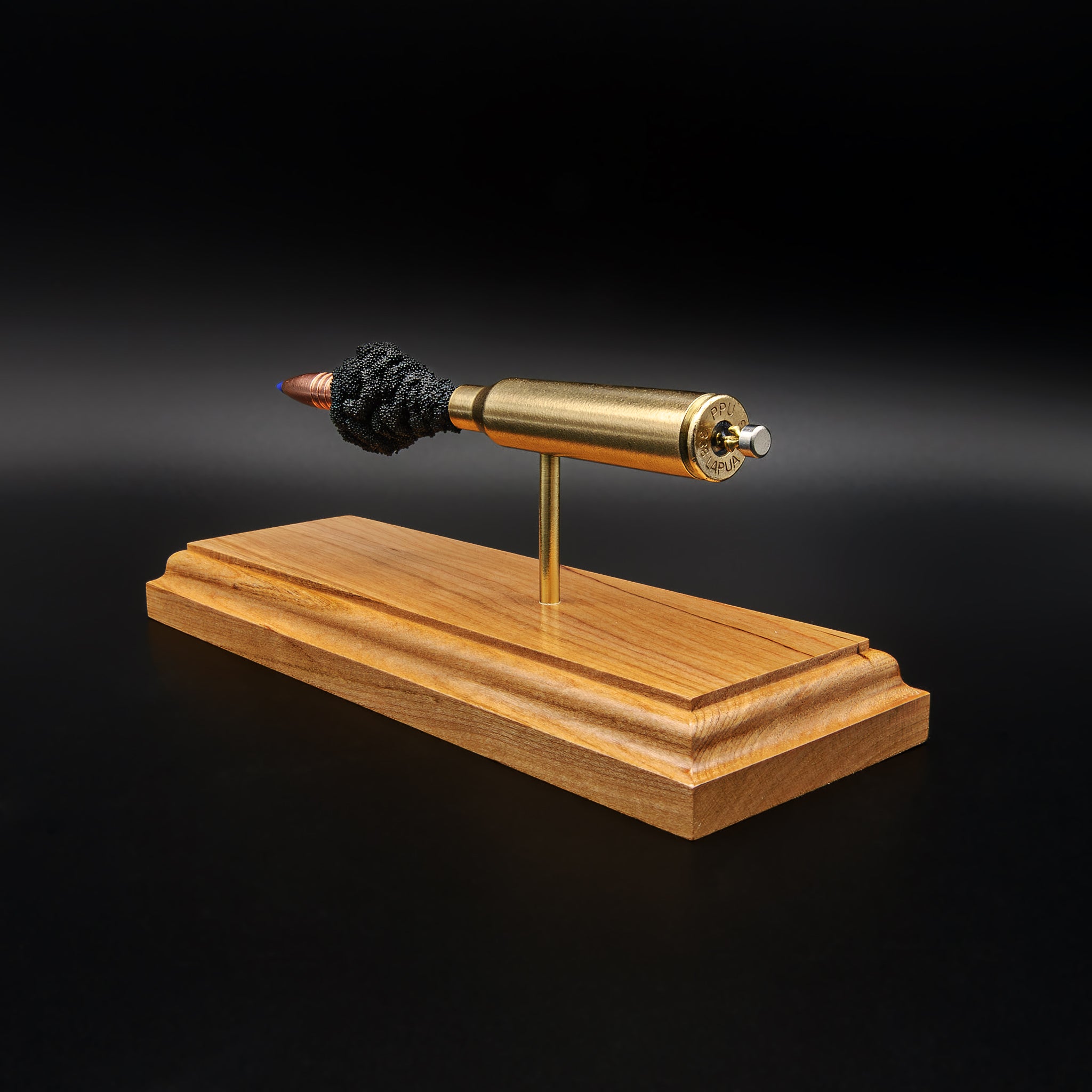 Back perspective of .338 Lapua Magnum Barnes TTSX model highlighting headstamp and component spacing on cherry base