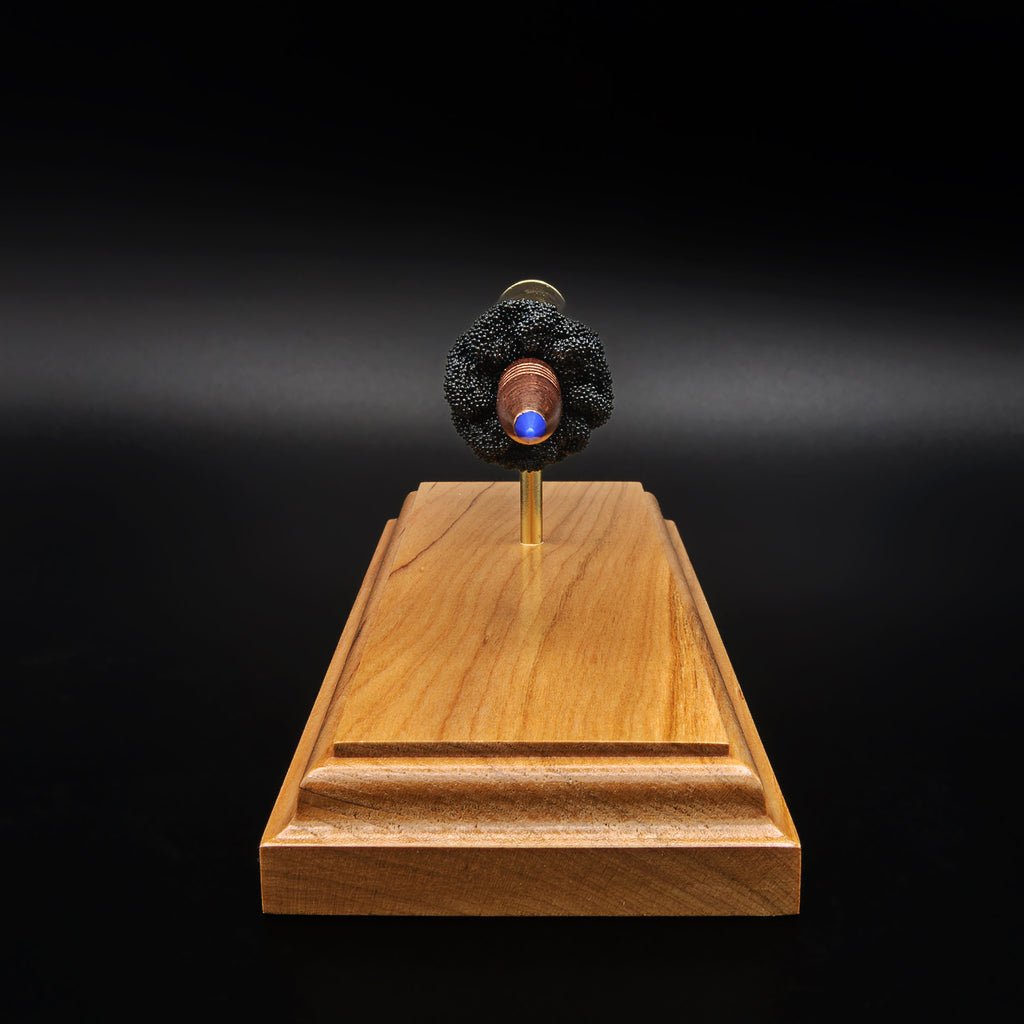 Front angled view of Barnes TTSX bullet in .338 Lapua Magnum exploded display on cherry wood base