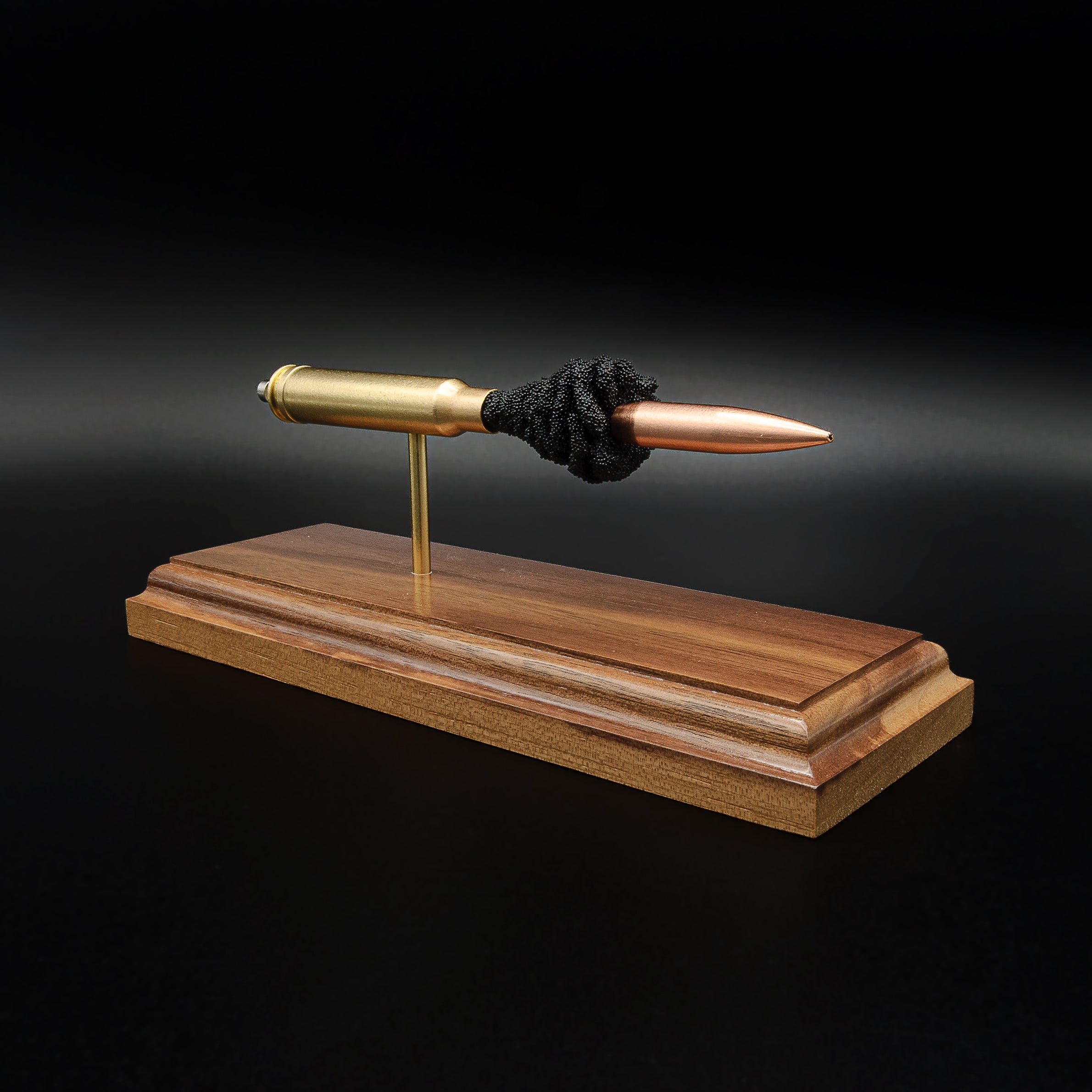 Left-side angle of a .338 Winchester Magnum exploded ammunition display with a Sierra MatchKing HPBT 300gr projectile, exposed simulated powder, and walnut wood base.