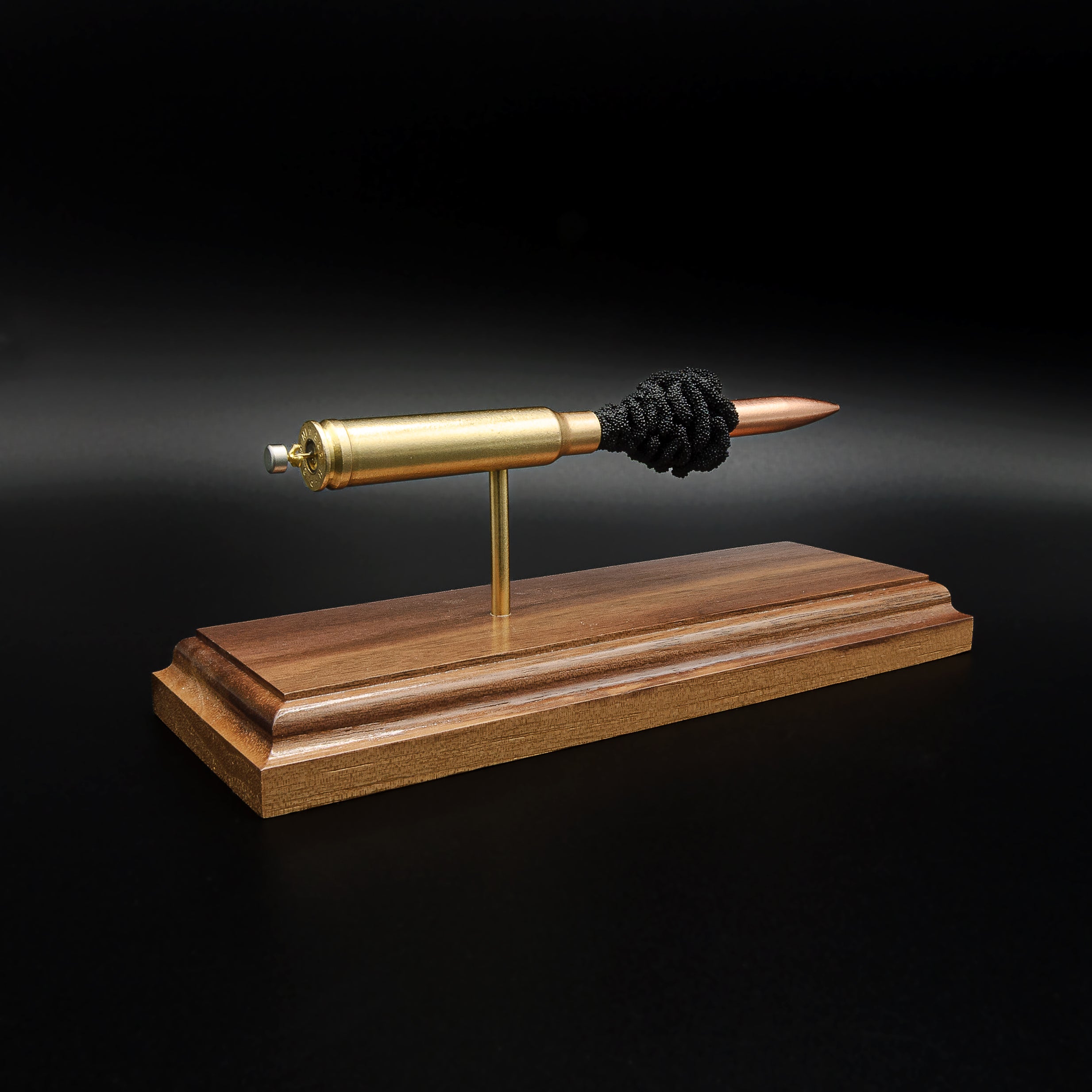 Rear-left perspective of a handcrafted .338 Winchester Magnum cartridge display highlighting the brass case, Sierra MatchKing HPBT 300gr bullet, and walnut presentation base.
