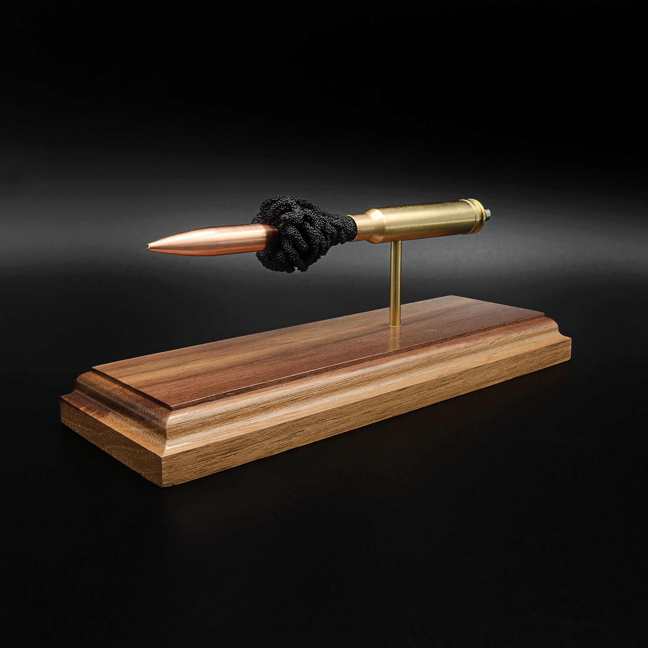 Front-right three-quarter view of a .338 Winchester Magnum anatomy cartridge display with a Sierra MatchKing HPBT 300gr bullet mounted on a handcrafted walnut wood base.