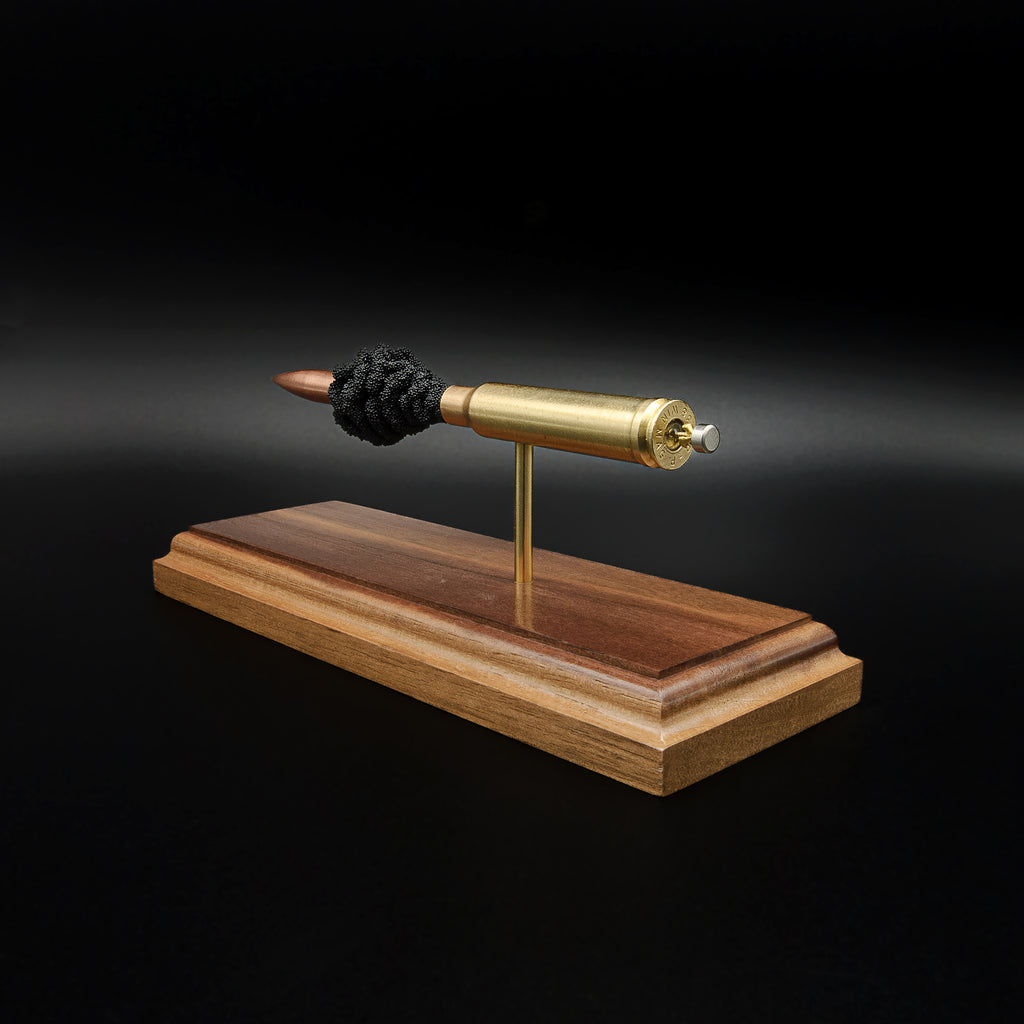 Rear-right angle of a handcrafted .338 Winchester Magnum exploded cartridge display showing the case head, primer assembly, brass case, Sierra MatchKing HPBT 300gr bullet, and walnut display base.