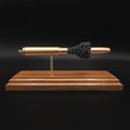 Front view of a .416 Rigby Hornady DGX cartridge anatomy display showing the primer cup, anvil, cartridge case, simulated powder, and projectile on a walnut wood base.
