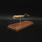 Front angled view of a .416 Rigby Hornady DGX cartridge anatomy display with the primer cup, anvil, cartridge case, simulated powder, and projectile mounted on a walnut wood base.