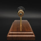 Rear view of a .416 Rigby Hornady DGX cartridge anatomy display showing the cartridge case head, primer cup, anvil, simulated powder, and projectile on a walnut wood base.