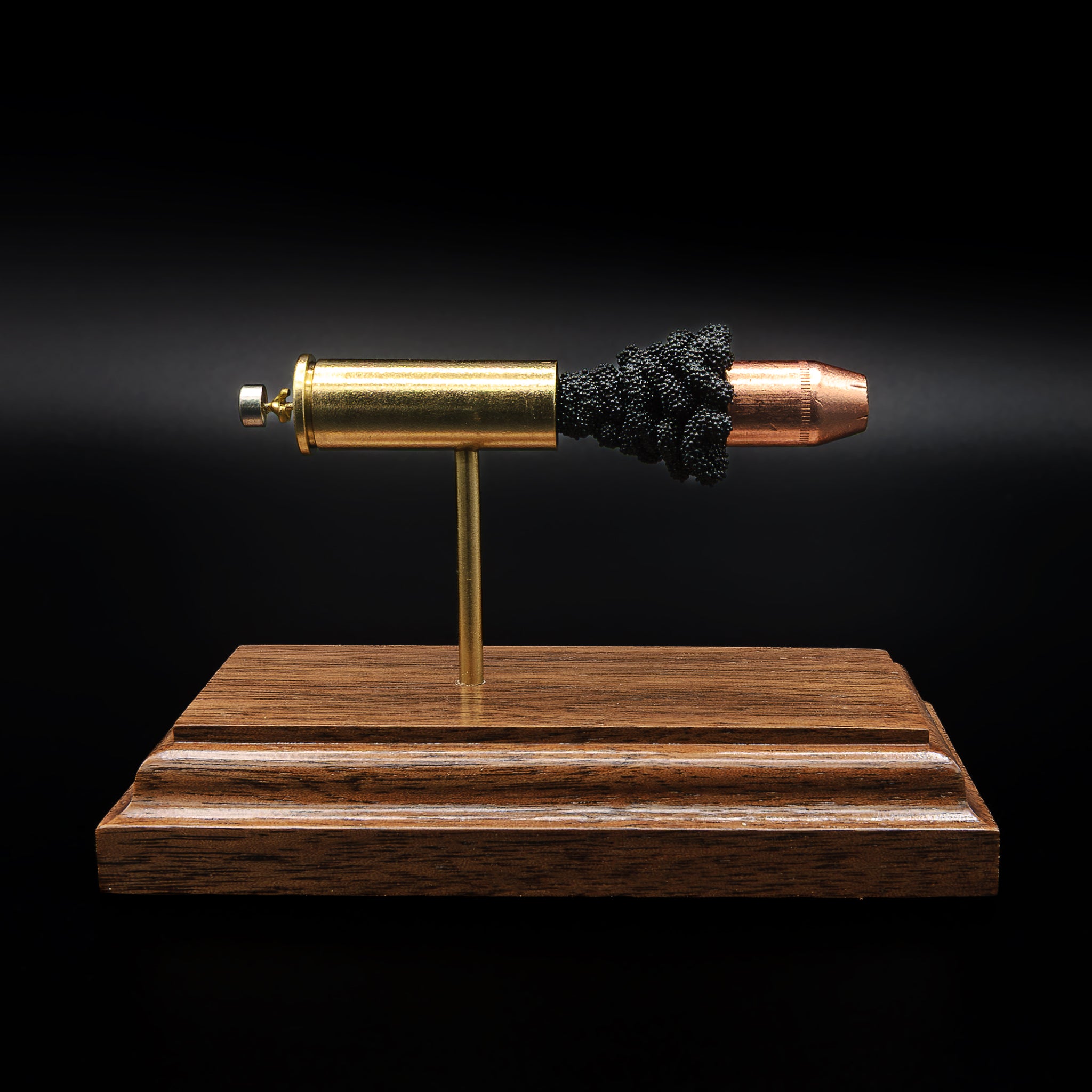 A .44 Remington Magnum cartridge displayed in an exploded layout on a walnut base, with the brass case, powder cluster, and hollow point bullet aligned in a straight line
