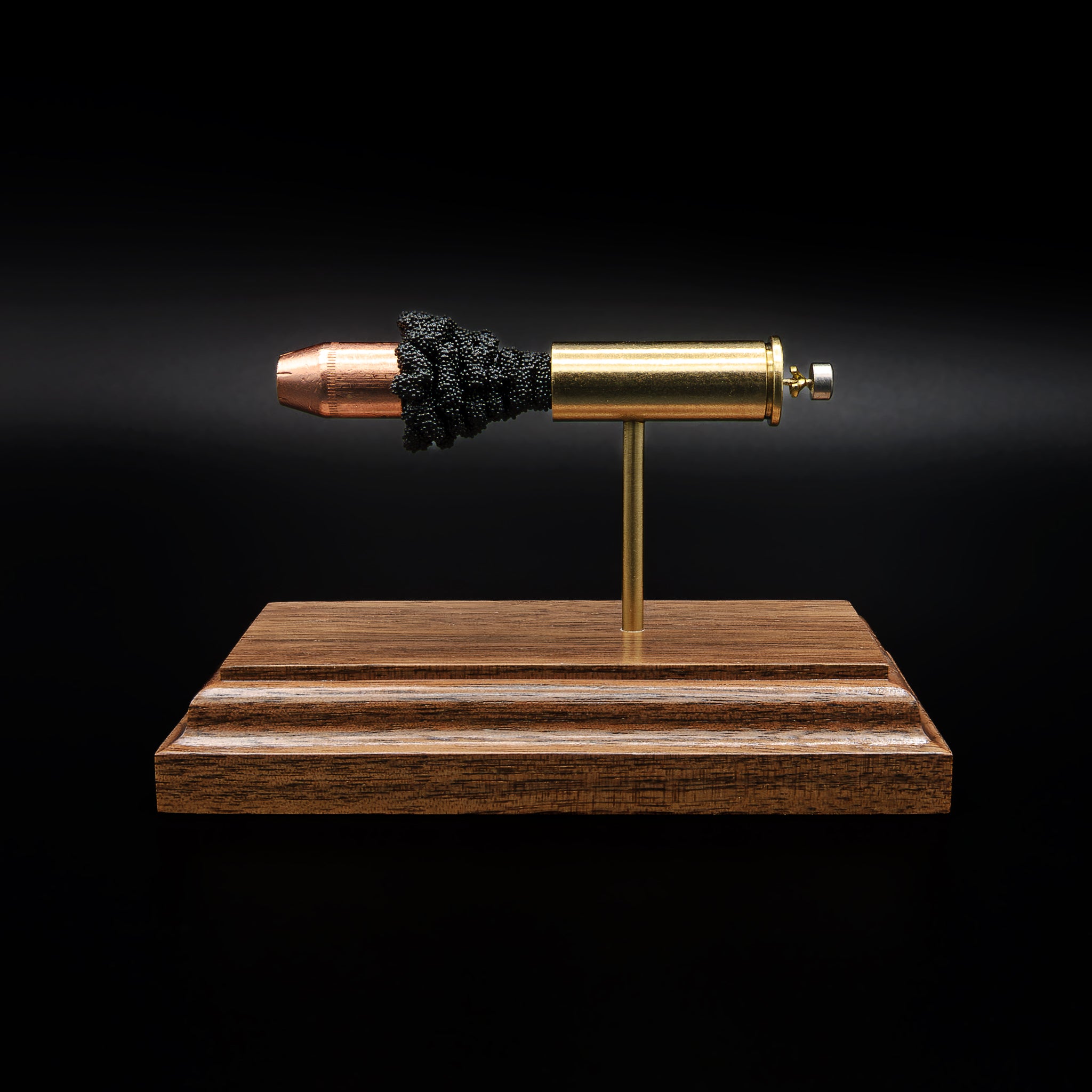Side view of a .44 Magnum cartridge model facing the opposite direction, showing the alignment of the bullet, powder, and casing on a wood base