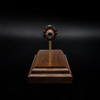 Head-on view of a .44 hollow point bullet centered above a walnut base, with the opening of the projectile clearly visible