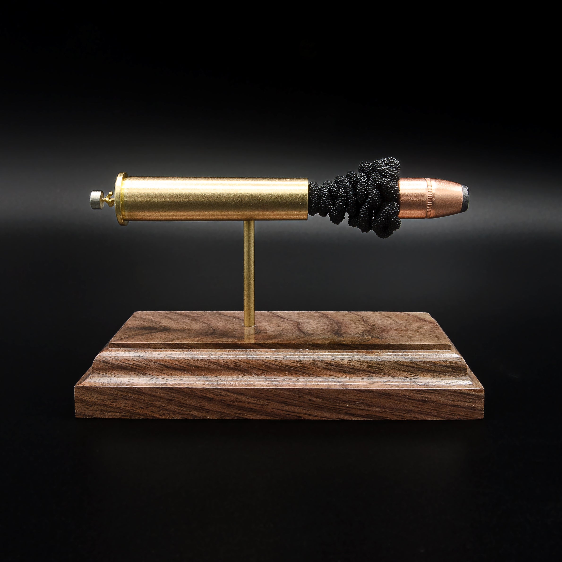 Front profile of a handcrafted .45-70 Government exploded cartridge display featuring a 300gr Hornady InterLock HP bullet with simulated powder on a walnut wood base.