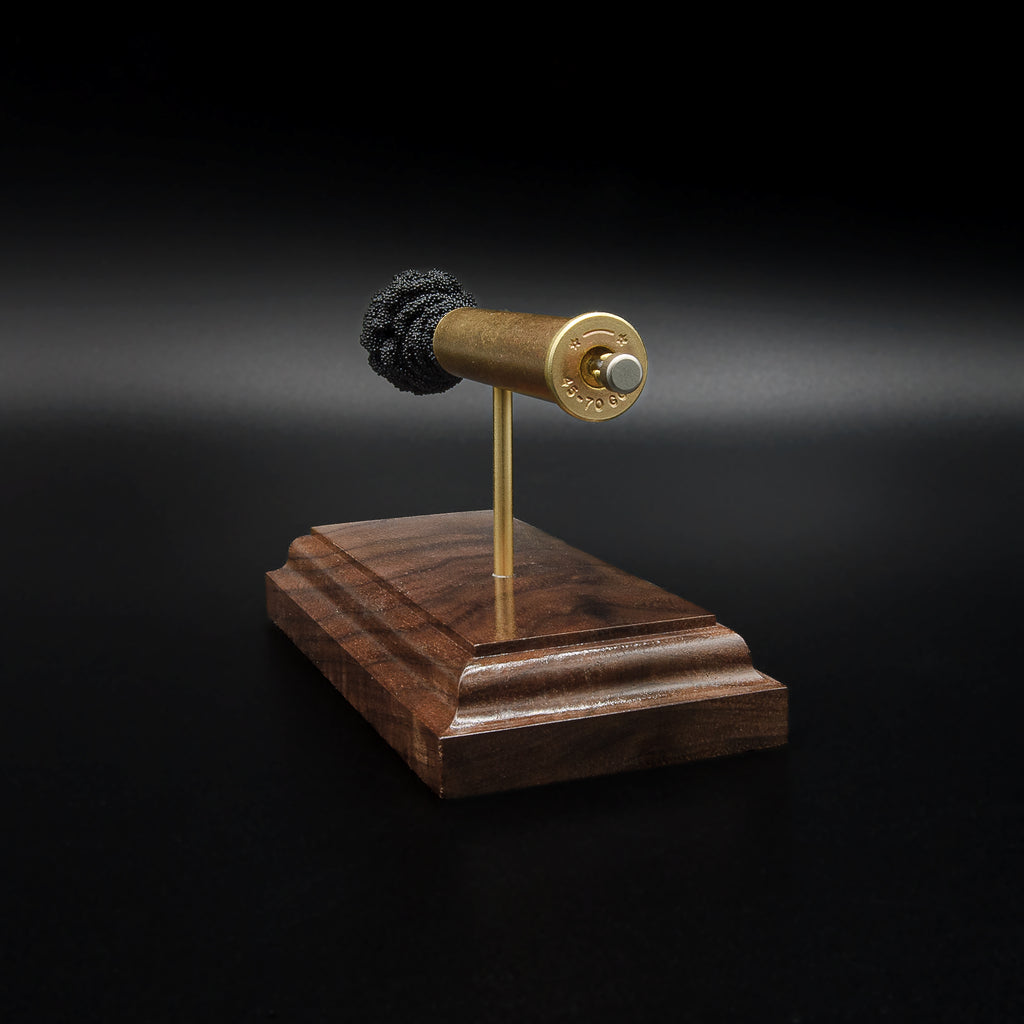Close rear perspective of a .45-70 Government anatomy display highlighting the brass case head, primer details, and handcrafted walnut base.
