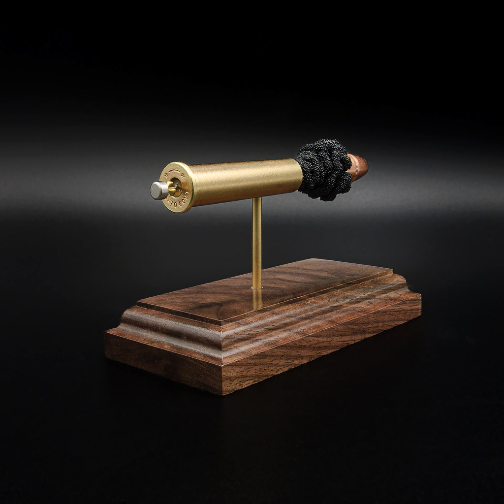 Angled rear view of an inert .45-70 Government exploded cartridge with a Hornady 300gr InterLock hollow point bullet, simulated powder, and walnut display base.