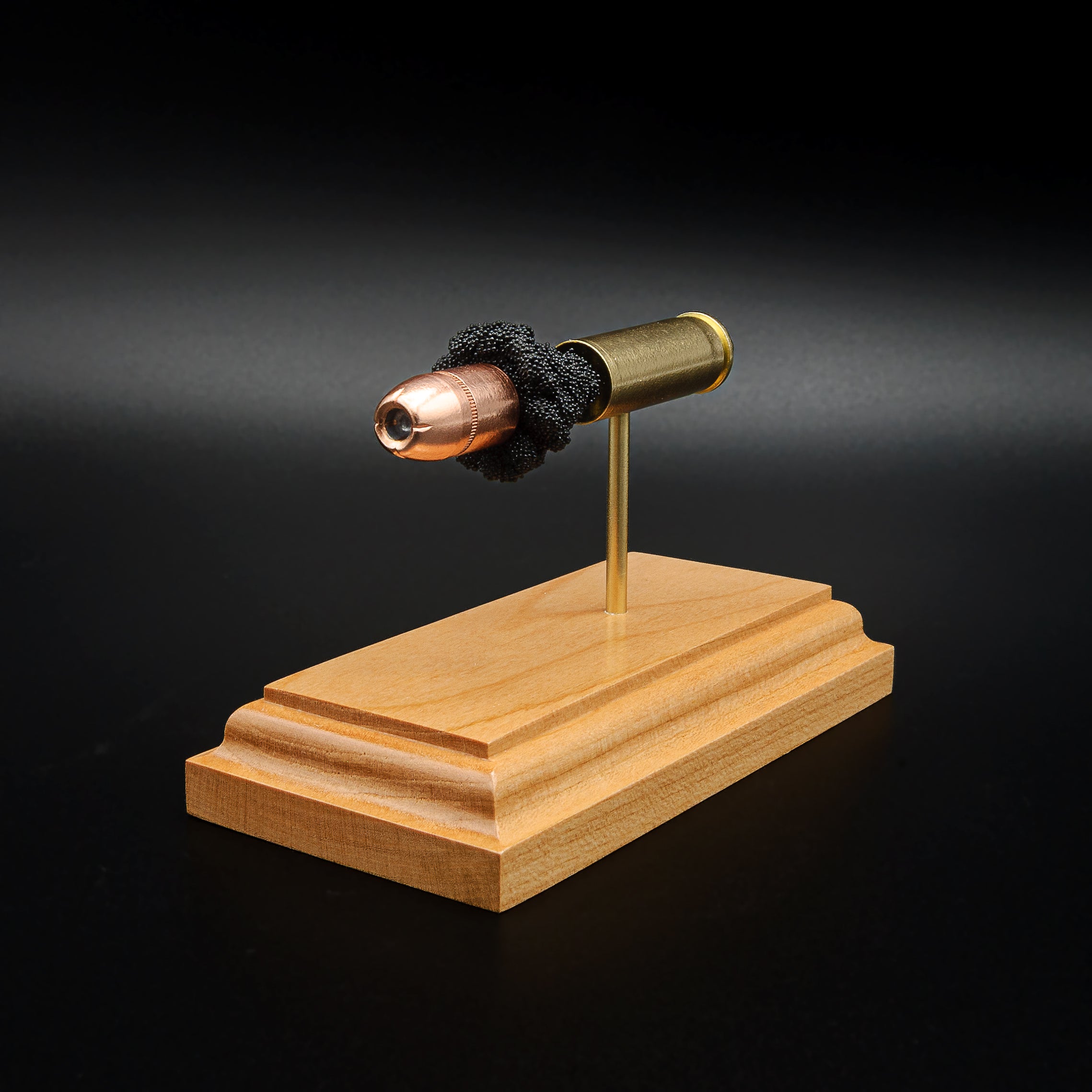 Front-right angle of an inert .454 Casull anatomy cartridge display showcasing the Hornady XTP JHP 300gr hollow point bullet, exposed simulated powder, and handcrafted cherry wood base.
