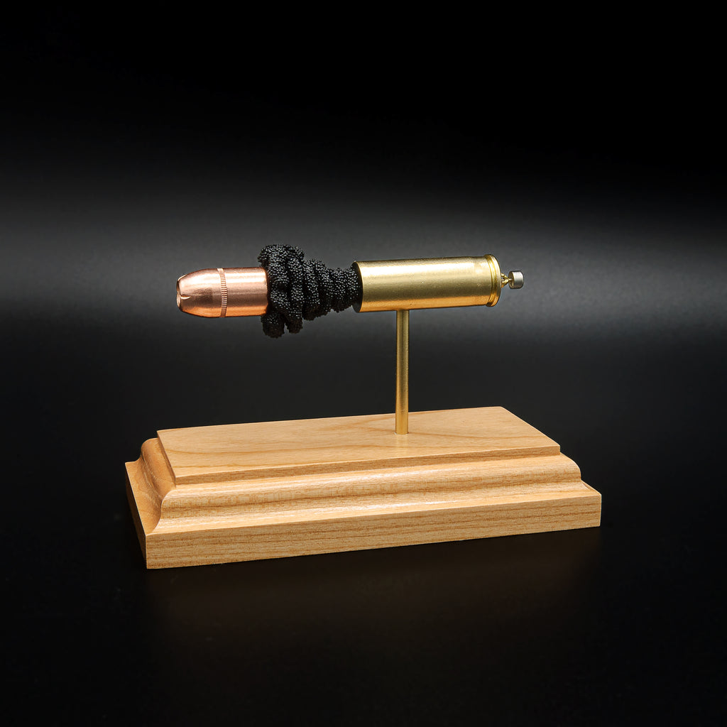 Side profile of a .454 Casull exploded ammunition display with a Hornady XTP JHP 300gr bullet, brass case, exposed simulated powder, and cherry wood presentation base.