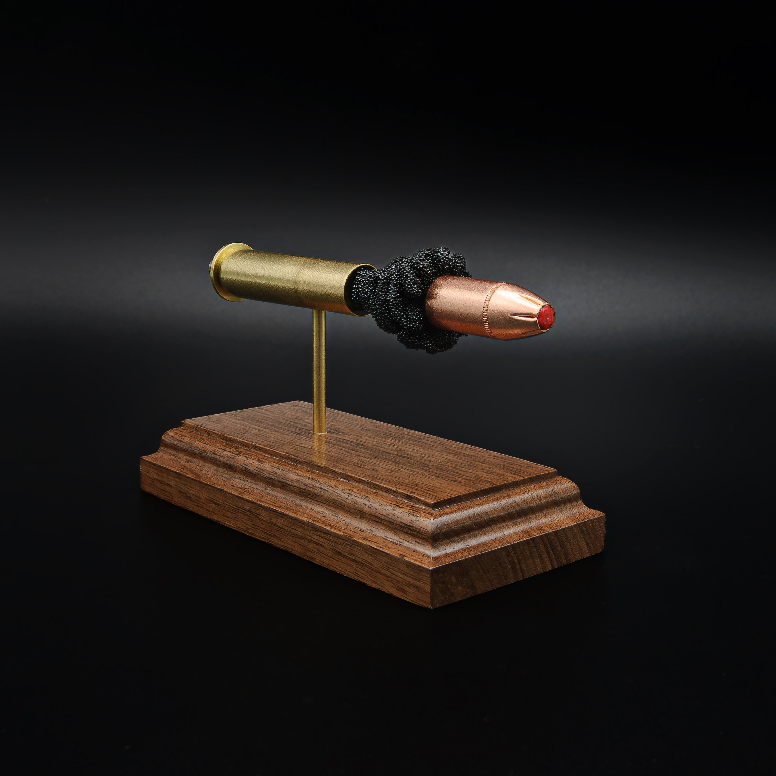 Left side view of a 45-70 Government Hornady Sub-X 410gr cartridge anatomy display with the primer cup, anvil, brass case, simulated powder, and projectile visible on a walnut base.