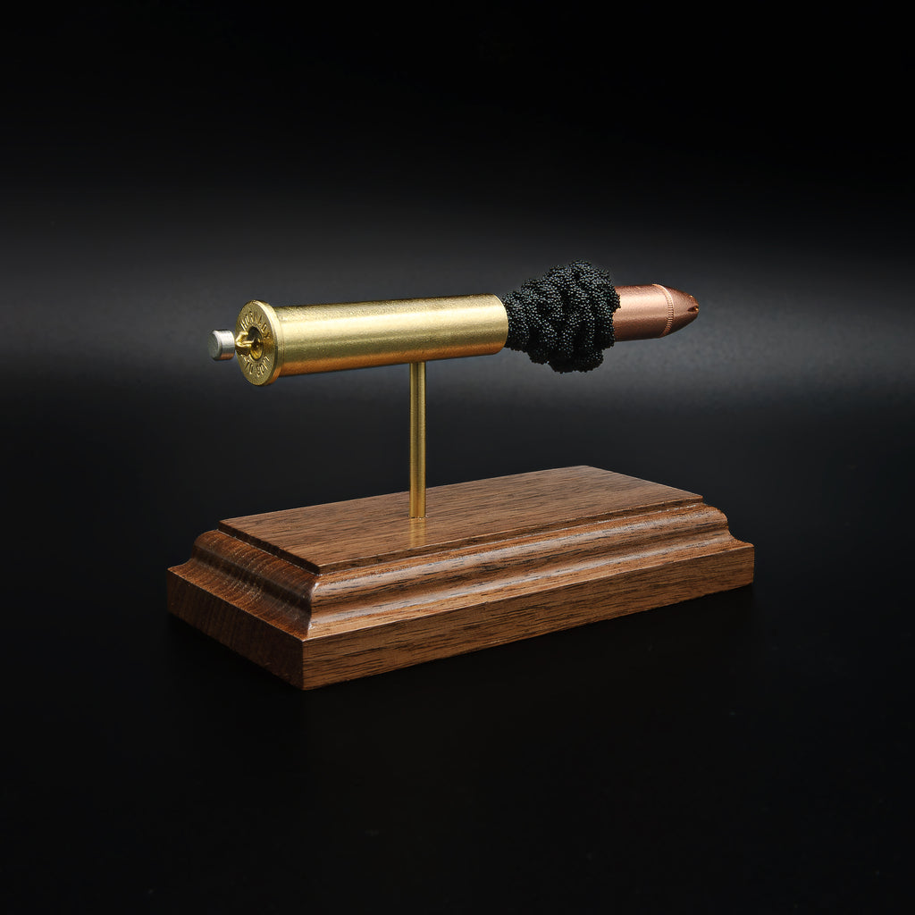 Rear left angle of a 45-70 Government Hornady Sub-X 410gr cartridge anatomy display showing the cartridge headstamp, primer cup, and exposed internal components on a walnut base.
