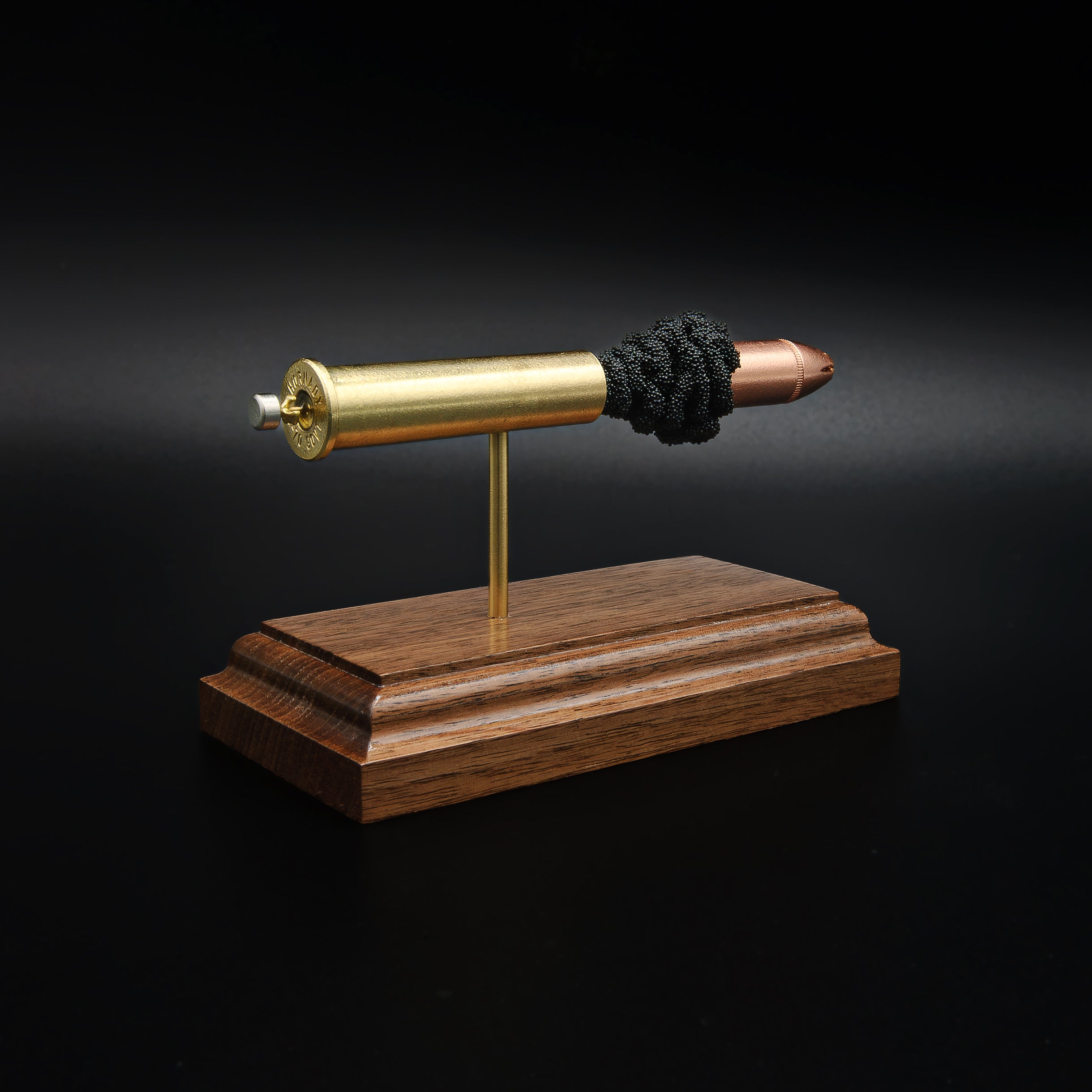 Rear left angle of a 45-70 Government Hornady Sub-X 410gr cartridge anatomy display showing the cartridge headstamp, primer cup, and exposed internal components on a walnut base.