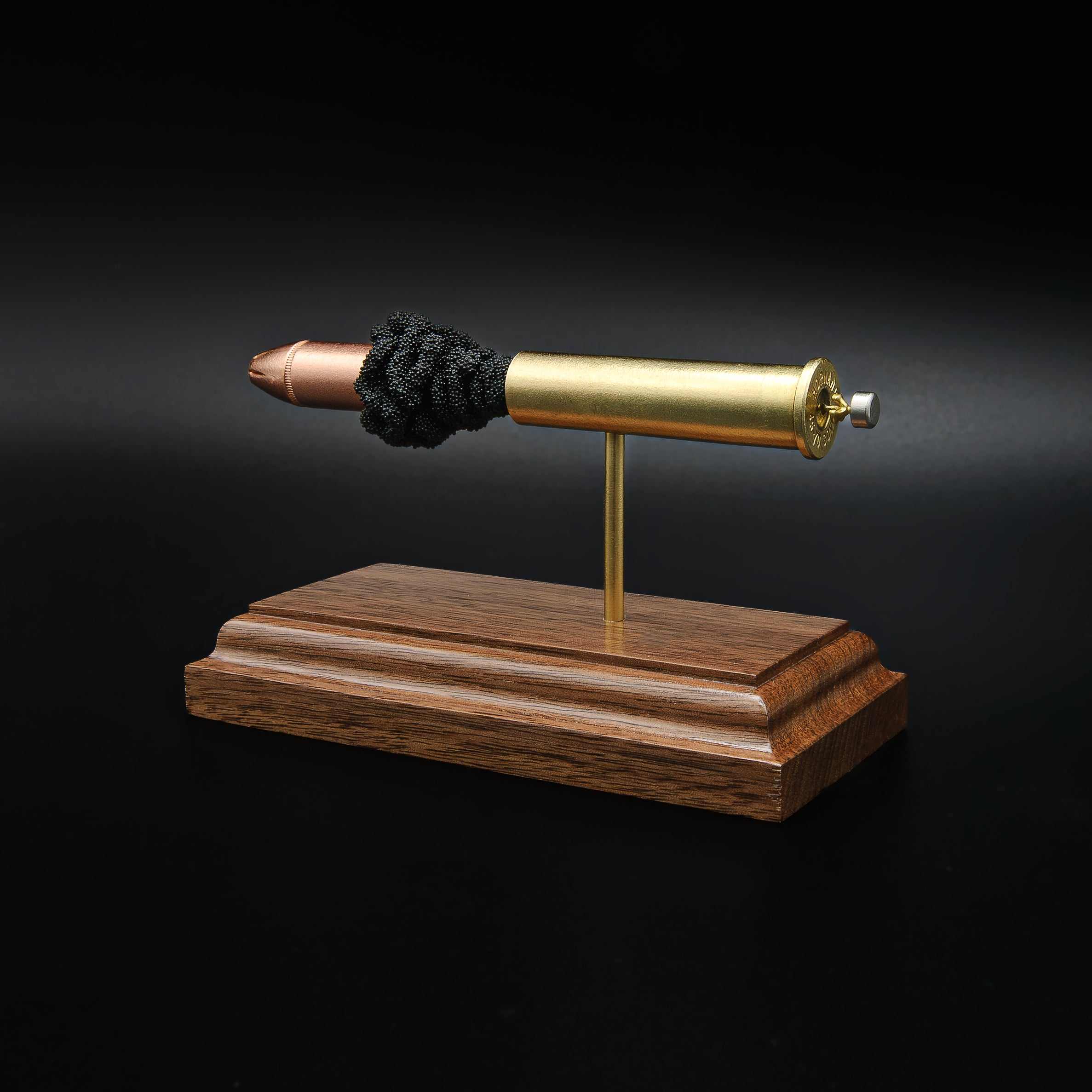 Rear right angle of a 45-70 Government Hornady Sub-X 410gr cartridge anatomy display highlighting the exposed simulated powder, brass case, and Hornady Sub-X projectile on a walnut base.