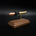 Front right angle of a 45-70 Government Hornady Sub-X 410gr cartridge anatomy display with the primer cup, anvil, brass case, simulated powder, and projectile visible on a walnut base.