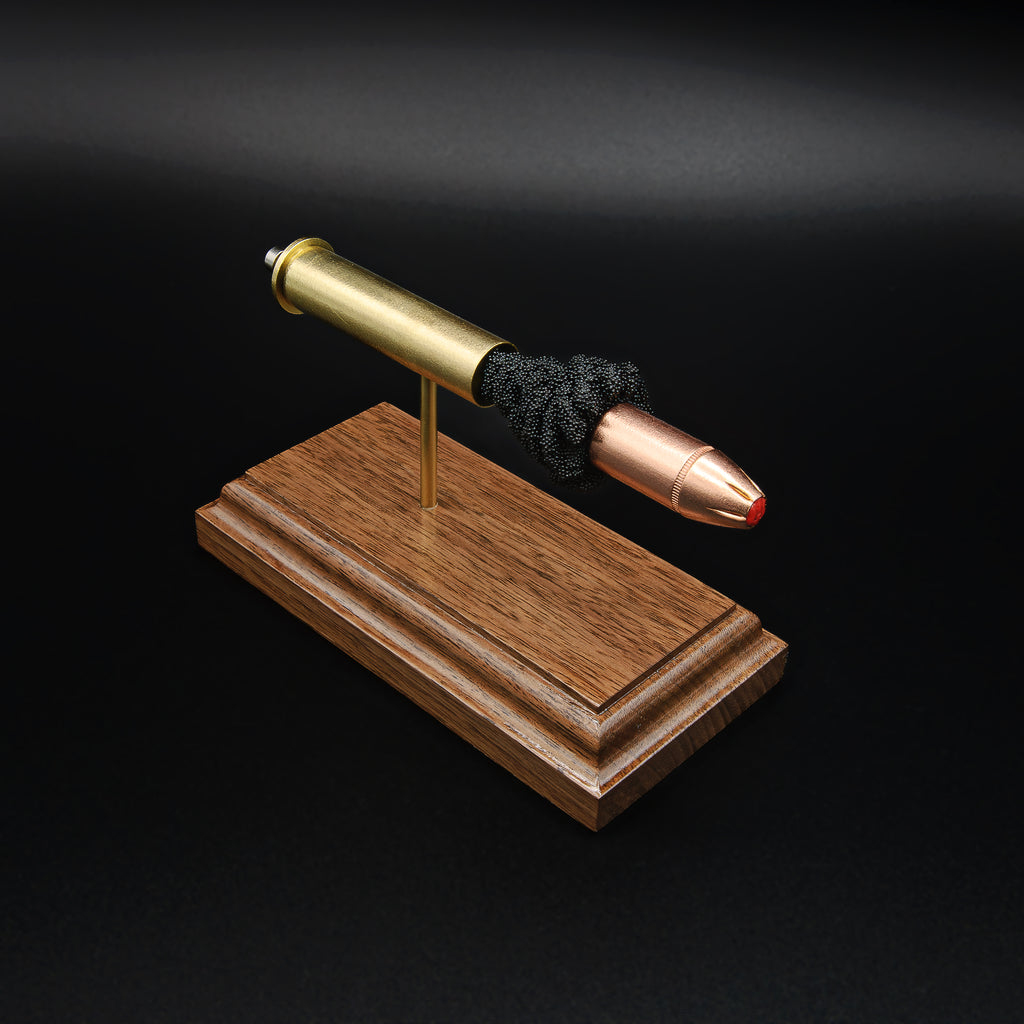 Top front angle of a 45-70 Government Hornady Sub-X 410gr cartridge anatomy display showcasing the exposed simulated powder, polymer-tipped projectile, and brass case on a walnut base.