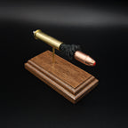Top front angle of a 45-70 Government Hornady Sub-X 410gr cartridge anatomy display showcasing the exposed simulated powder, polymer-tipped projectile, and brass case on a walnut base.