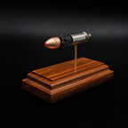 Front perspective of a .45 caliber polymer-tipped bullet in an exploded cartridge display, mounted on a rosewood base