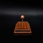 Head-on view of a .45 polymer-tipped bullet centered above a rosewood base, with the red tip clearly visible