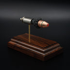 Angled view of a .45 Auto Critical Duty cartridge model on a rosewood base, highlighting the red FlexLock tip and green sealant band
