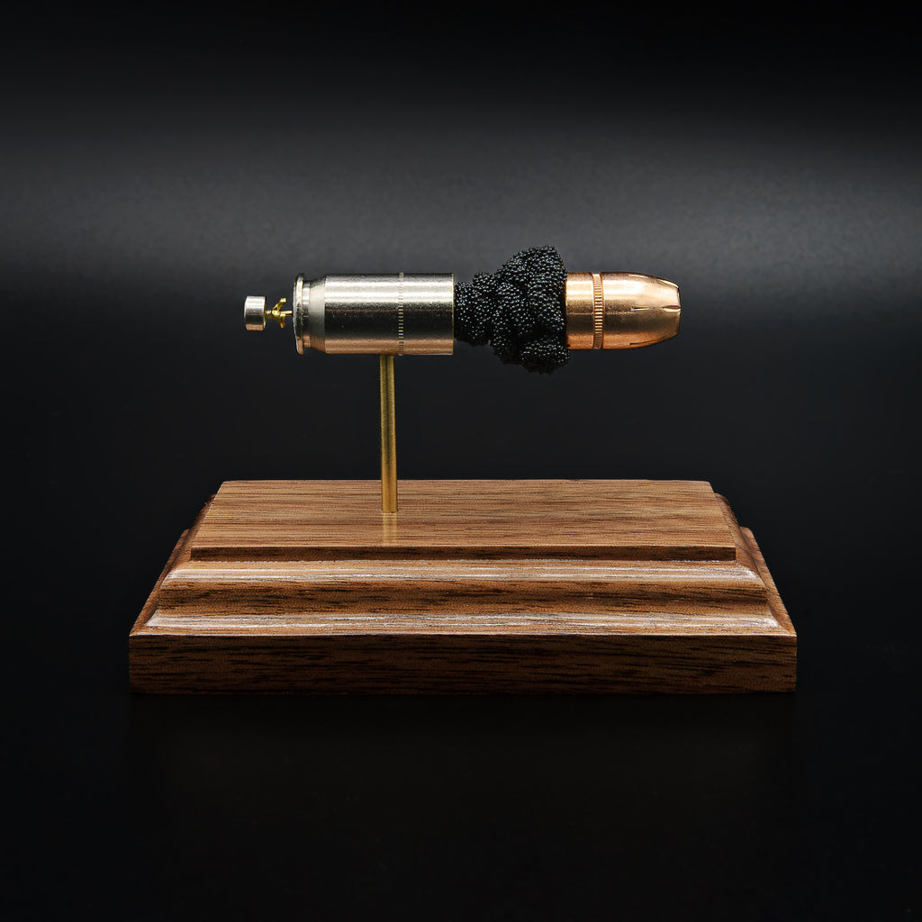 Front view of a .45 Auto Federal 230gr HST JHP cartridge anatomy display showing the primer cup, anvil, cartridge case, simulated powder, and projectile on a walnut wood base.