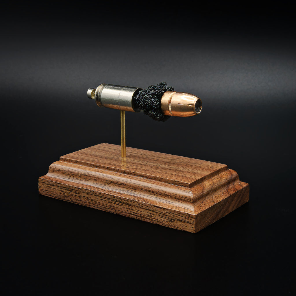 Angled view of a .45 Auto Federal 230gr HST JHP cartridge anatomy display highlighting the projectile, simulated powder, cartridge case, primer cup, and anvil on a walnut wood base.