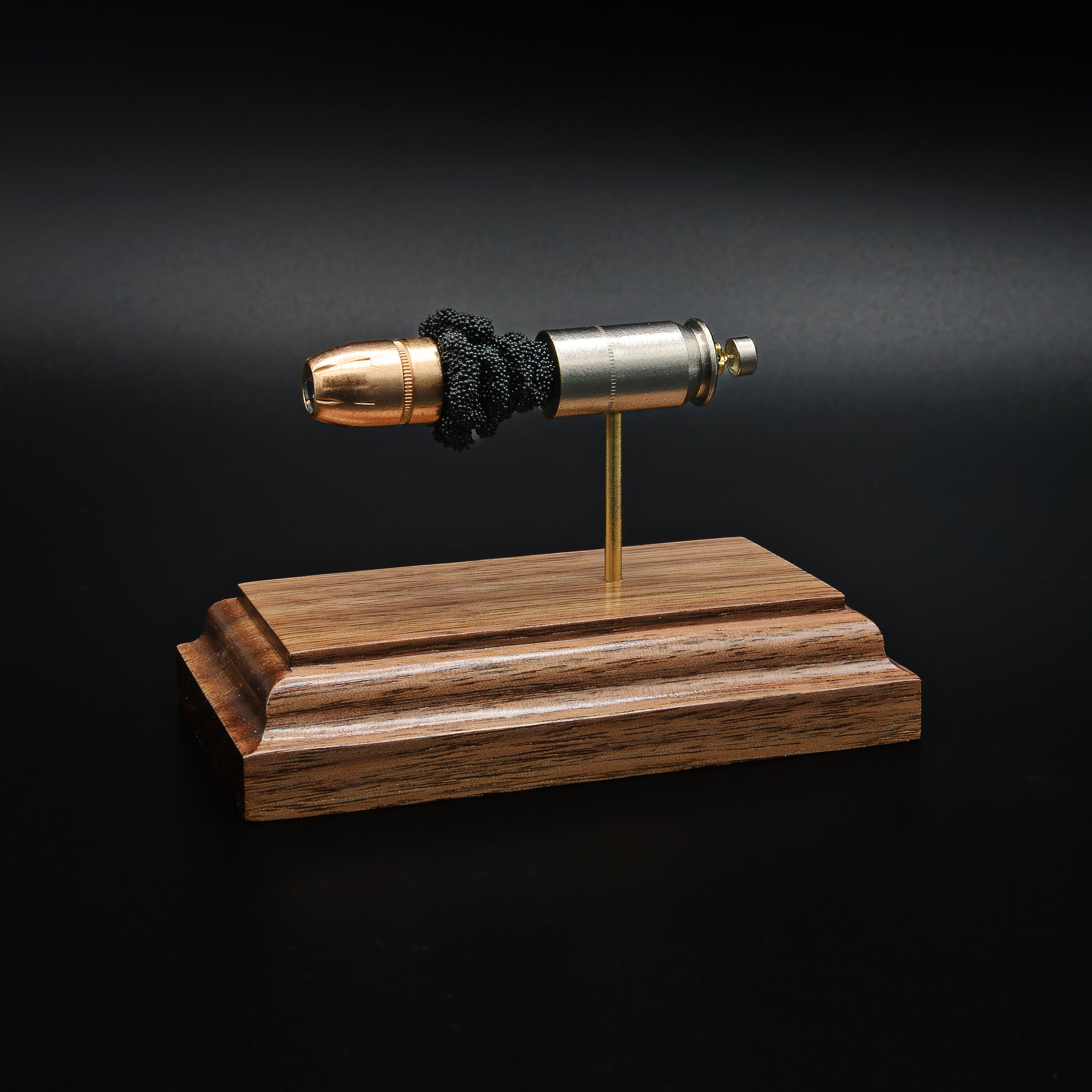 Angled opposite side view of a .45 Auto Federal 230gr HST JHP cartridge anatomy display featuring the primer cup, anvil, cartridge case, simulated powder, and projectile on a walnut wood base.