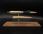 Side profile of .50 BMG comparison display featuring intact cartridge and separated components on walnut base