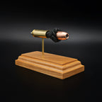 Side view of a .50 Action Express Hornady Custom 300gr XTP cartridge anatomy display with the primer cup, anvil, cartridge case, simulated powder, and projectile visible on a cherry wood base.