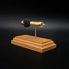 Angled rear view of a .50 Action Express Hornady Custom 300gr XTP cartridge anatomy display featuring the primer cup, anvil, cartridge case, simulated powder, and projectile on a cherry wood base.